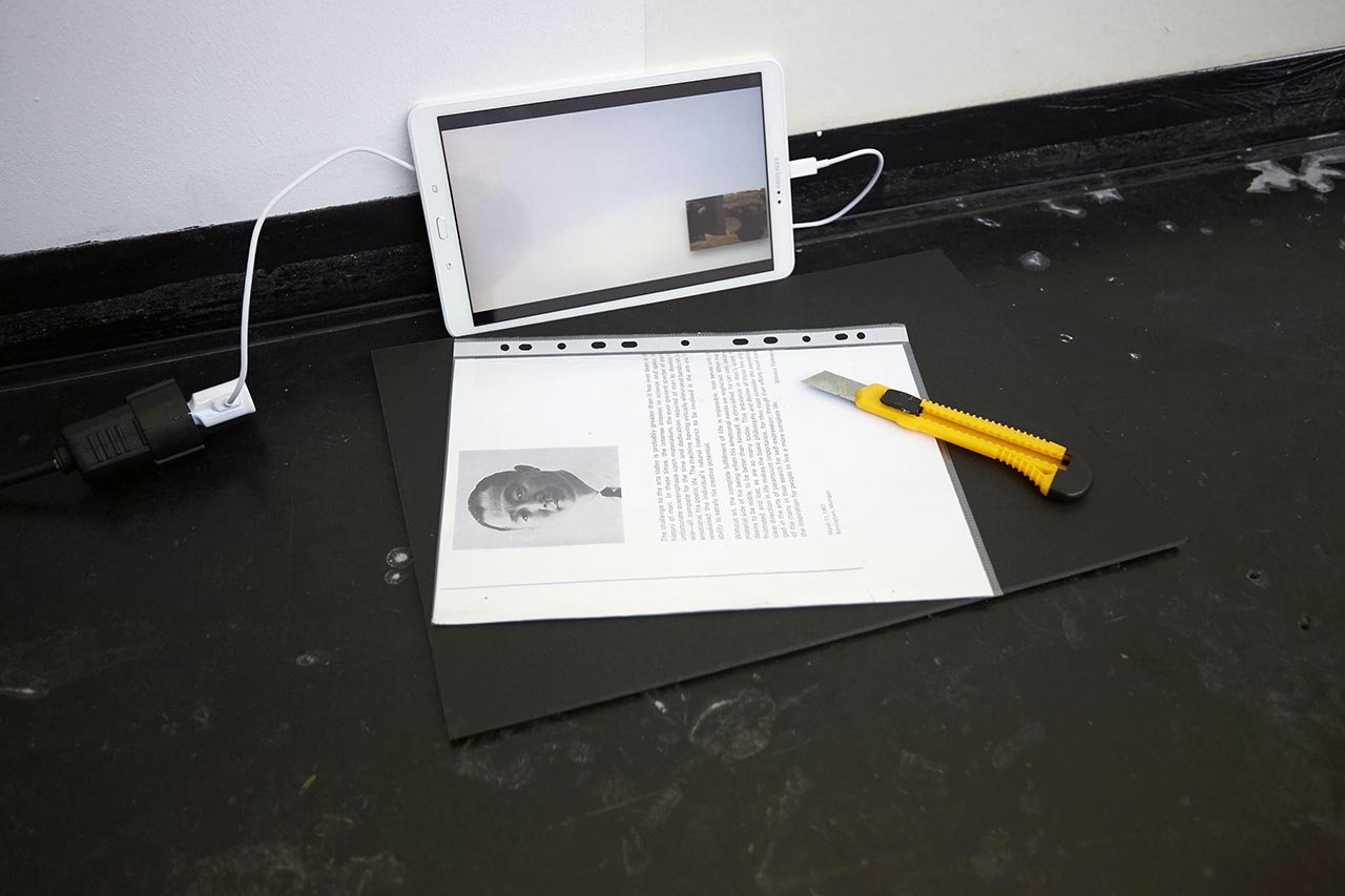 HIGH RES LOW BROW — a laptop and a printed sheet on the floor