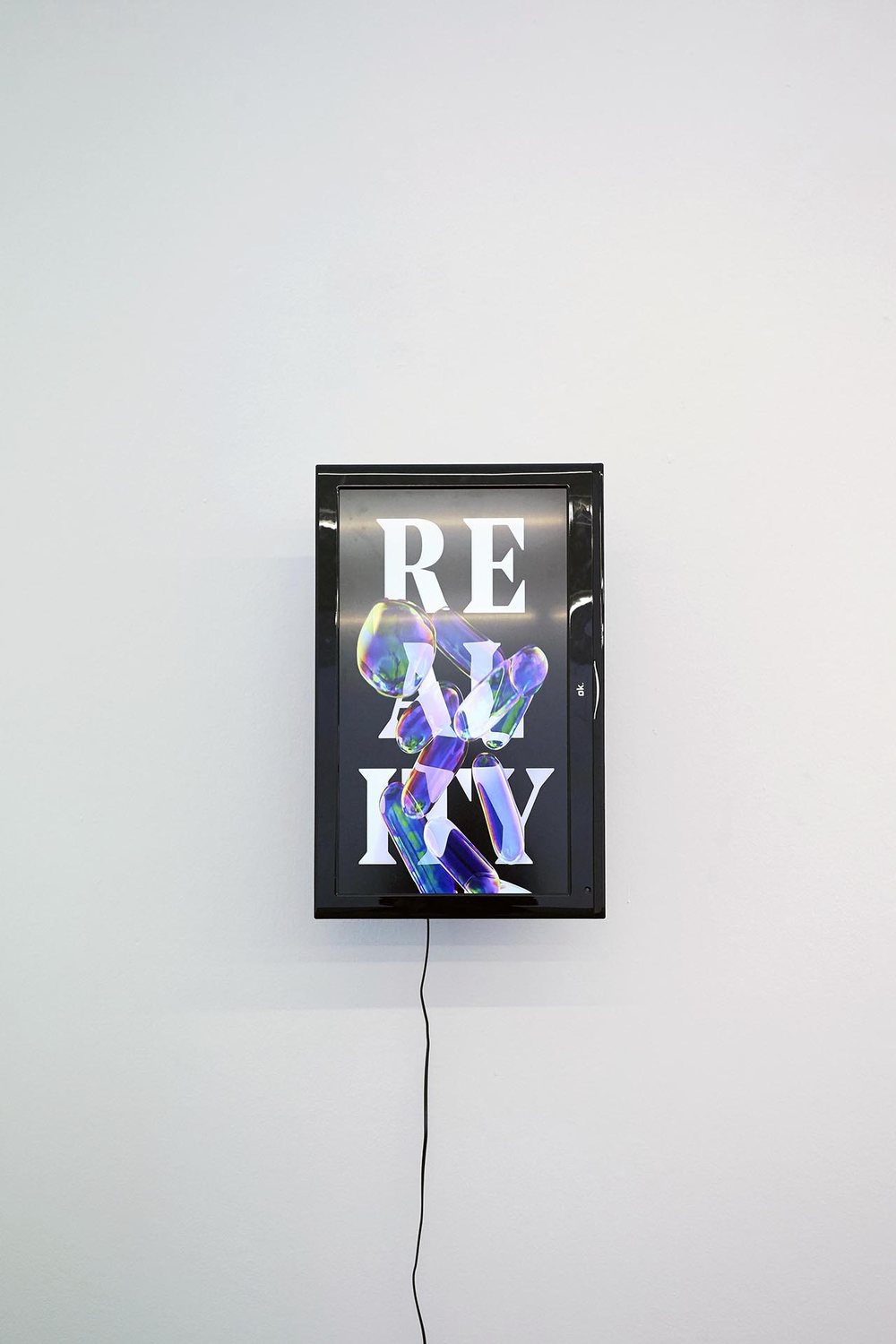 HIGH RES LOW BROW — a lightbox spelling REALITY in shifting colours