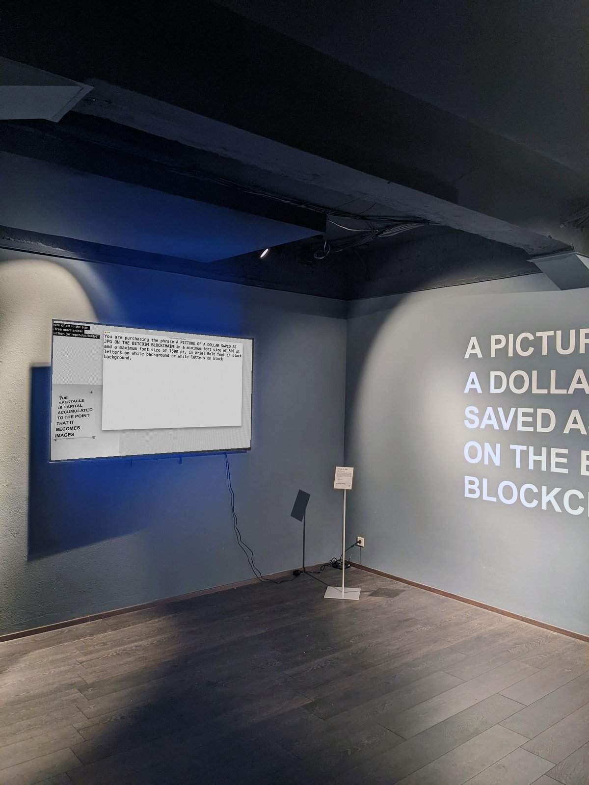 TRIBUTE TO GUY — installation view with the definition placard and the blue-lit wall text