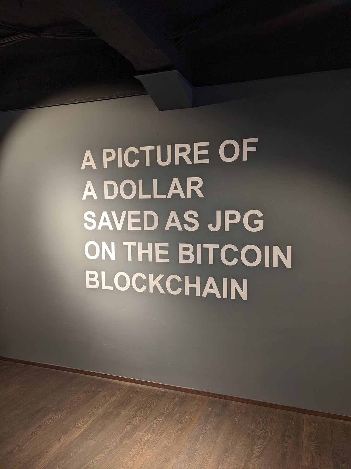 TRIBUTE TO GUY — the wall text under warm gallery light